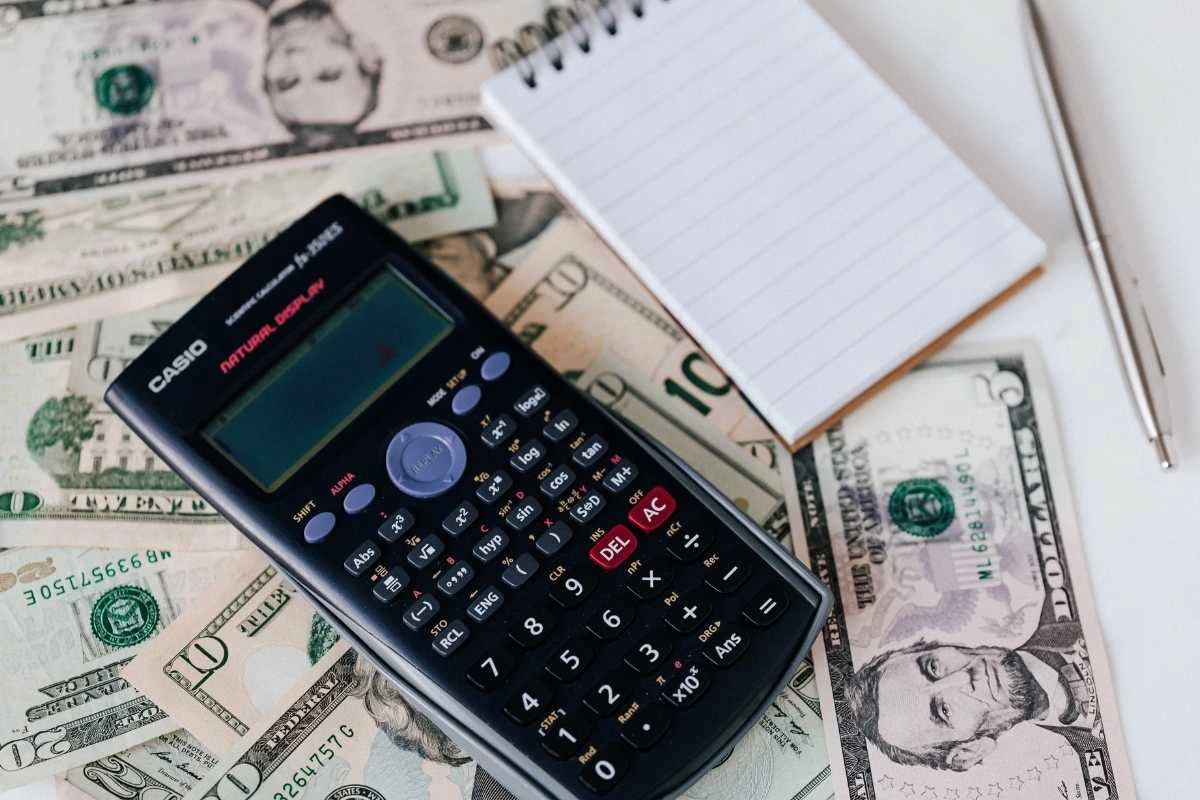 A calculator and notebook on US Dollars